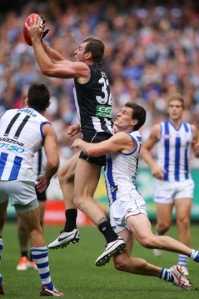 Travis Cloke takes a strong mark as Scott Thompson of the Kangaroos tries to bring him down.