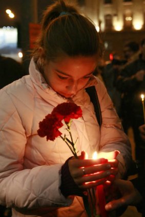 A Russian holds candles and flowers in memory of the victims of a blast near the Lubyanka metro station in Moscow.