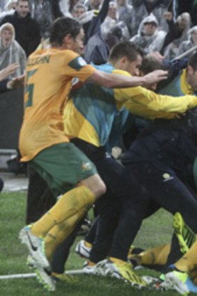That'll do: The Socceroos celebrate after Josh Kennedy's late goal.