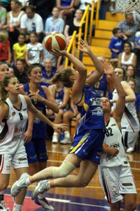 Stretched: Boomer Rebecca Cole leaps over a Townsville opponent in an attempt to score at the Veneto Club on Saturday night.
