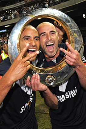 Archie Thompson and Kevin Muscat celebrate last year's grand final triumph. The star pair will be sorely missed by Melbourne Victory over the next month.