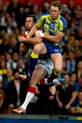 Pat Richards of Wigan and Joel Monaghan of Warrington compete for a high ball.