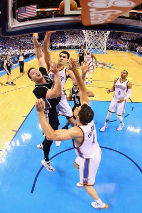 Aron Baynes drives to the basket against Nick Collison and Steven Adams of the Oklahoma City Thunder during San Antonio's win in the Western Conference Finals.