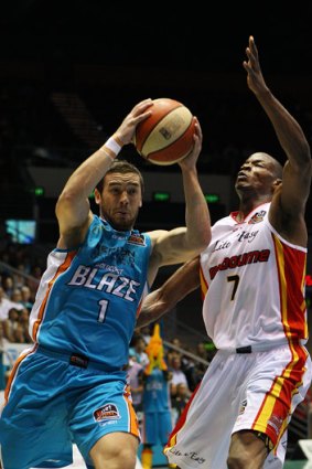Happier times... Adam Gibson of the Gold Cast Blaze drives past Ron Dorsey of the Melbourne Tigers.