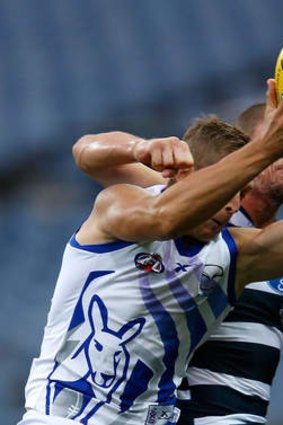 North Melbourne's Nick Dal Santo is too strong for Geelong's James Kelly.