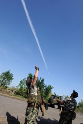 Pro-Russia militants follow a Ukrainian army plane during clashes in the east of the country on Wednesday. 