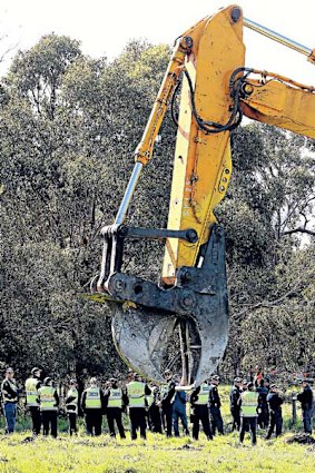 A tree harvester rests, while police stand ready to arrest Frankston Bypass protesters.