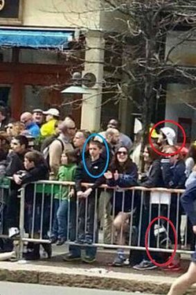 Boston marathon suspect in white hat smiles in front of a backpack believed to contain a bomb. In front is eight-year-old Martin Richard, who was killed in the attack.