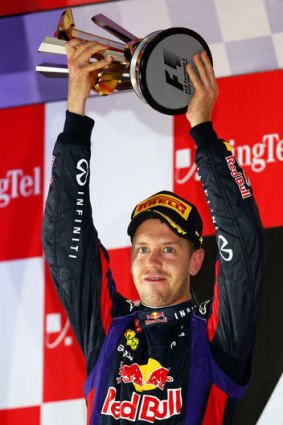 Germany's Sebastian Vettel of Red Bull racing lifts the trophy after claiming the Singapore Formula One Grand Prix.