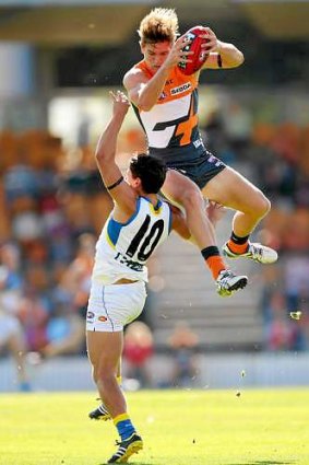 Giant leap: Adam Tomlinson marks over the Suns' Dion Prestia in Gold Coast's victory at Manuka Oval on Saturday.