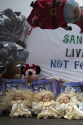Dolls are left at a memorial near Sandy Hook Elementary School, where a gunman shot dead 20 children last December.