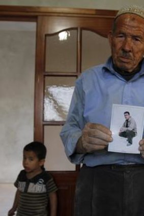 Deeb, the father of Palestinian prisoner Yusef Abu Adi, holds a picture of his son.