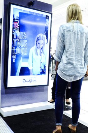 A David Jones customer at a photo booth that snaps a shot of them in jeans to share on social media.