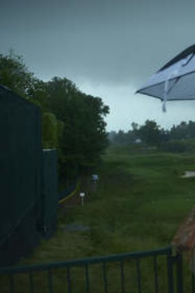 A man looks out over the 18th hole after play was suspended.