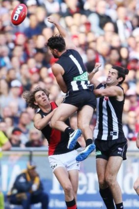 Joe Daniher (left) of the Bombers contests the ball against Alex Fasolo (centre) and Brodie Grundy of the Magpies.