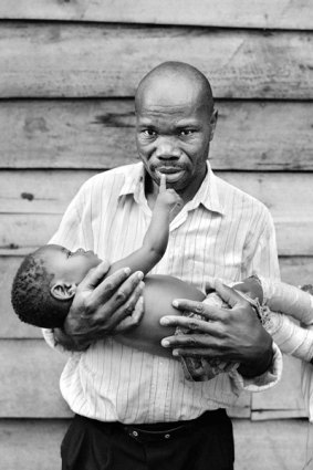 Ngarambe Rukambika cradles his son, shot in the leg during fighting in the Democratic Republic of Congo.