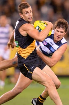 Brett Deledio is tackled by Geelong's Andrew Mackie at the MCG.