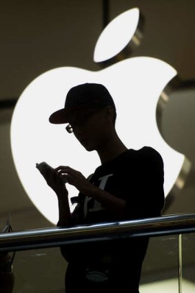 A man uses an iPhone in front of the Apple store in Hong Kong.