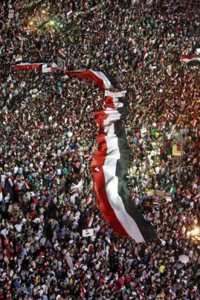 A large Egyptian flag flown through the crowd Tahrir Square.