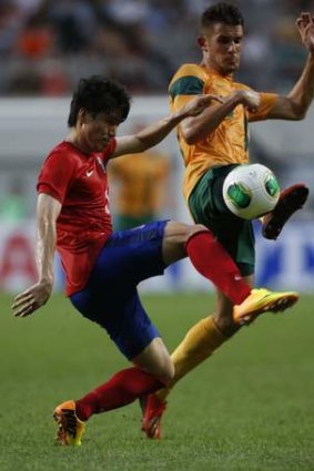 South Korea's Kim Chang-soo challenges Australia's  Dario Vidosic during an early East Asian Cup clash.