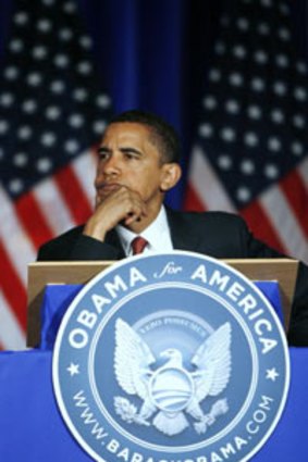 Barack Obama sitting behind his discarded campaign seal.