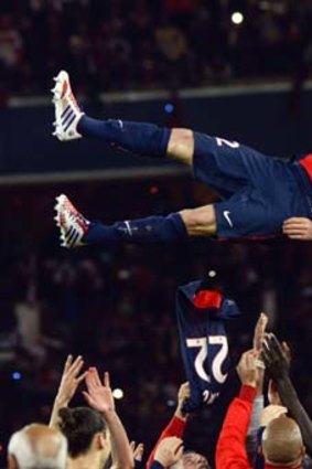 David Beckham's Paris St Germain teammates hoist him high after his last game in May.