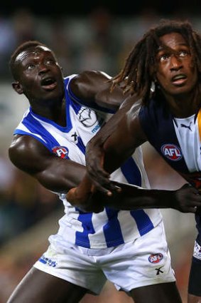 Majak Daw of the Kangaroos and Nic Naitanui of the Eagles contest a boundary throw in.