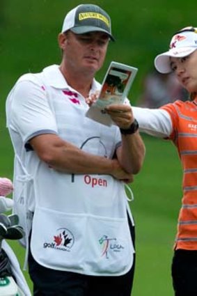 Na Yeon Choi of South Korea talks to her caddie Jason Hamilton as she prepares to hit her approach shot on the 18th hole during the first round of the CN Canadian Women's Open LPGA golf tournament at the Vancouver Golf Club in Coquitlam, British Columbia.