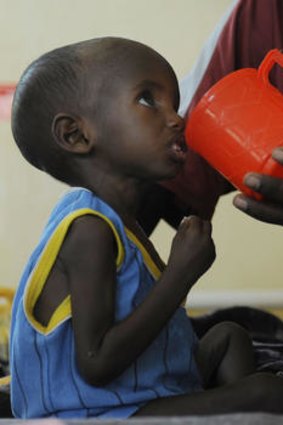 Aden, a three-year-old Somali refugee with his father Abdille, is fed at the stabilisation centre at Hagadere refugee area.