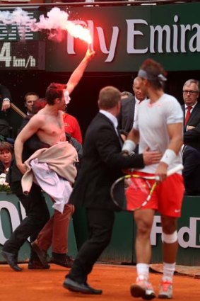 Fiery final: Rafael Nadal looks on as the protester is led away by security officials.