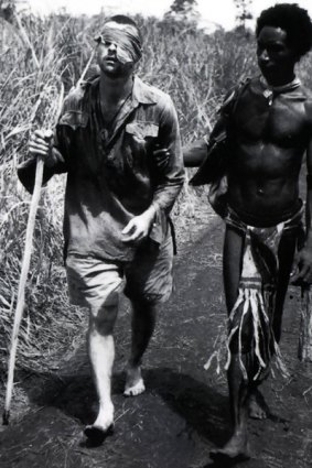Private "Dick" Whittington being helped by Fuzzy Wuzzy Angel Raphael Oimbari to a field hospital at Dobodura.  New Guinea - World War II. From the book by Allen and Unwin "Two hundred shots: Damien Parer, George Silk and the Australian War in New Guinea."