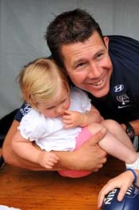 Coach Brett Ratten poses for a photowith some young fans.