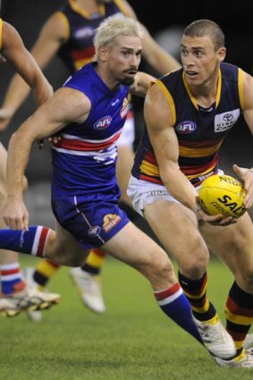 Adelaide's Simon Goodwin is chased by then Bulldog Jason Akermanis in April.