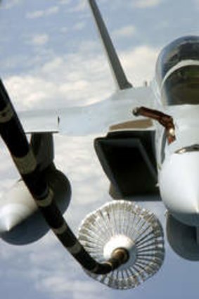 We'll take a dozen, thanks ... A Royal Australian Air Force F/A-18F Super Hornet air-to-air refuels from a United States Air Force tanker aircraft during its flight to Guam.