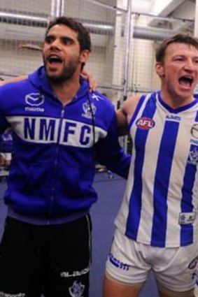 North Melbourne's Daniel Wells, Brent Harvey and Scott McMahon sing the team song in the rooms after their win over Essendon.