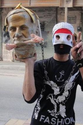 A Syrian demonstrator holds an effigy of former president  Hafez al-Assad during a protest against his son President Bashar al-Assad.