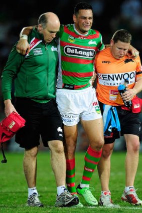 Not looking good: John Sutton of the Rabbitohs is assisted from the field after being injured against the rampant Cowboys.
