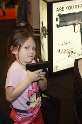 Targeting children ... a young girl with a pistol at a National Rifle Association event.