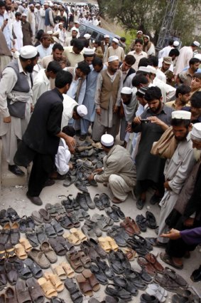 Survivors assemble the shoes of the dozens of victims of the mosque blast in north-west Pakistan.