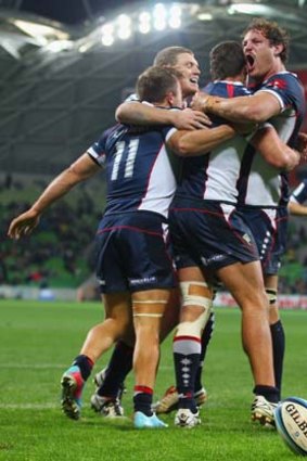 Rebel yell: Rebels players celebrate a try against the Waratahs on Friday night.