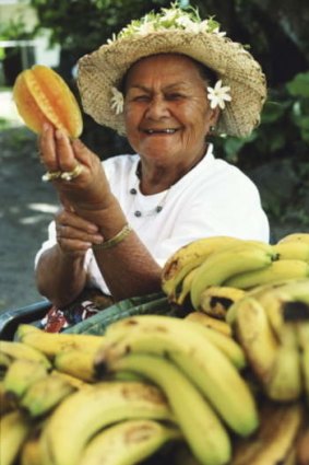 A woman selling produce at a market in Rarotonga, Cook Islands.
