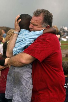 Horror: A teacher hugs a child at Briarwood Elementary school after the monstrous tornado flattened the building.