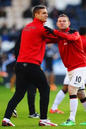 Pushing on: Wayne Rooney (right) warms up with Nemanja Vidic on Boxing Day.
