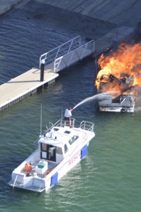 Rescuers fight the boat fire at Woodman Point.