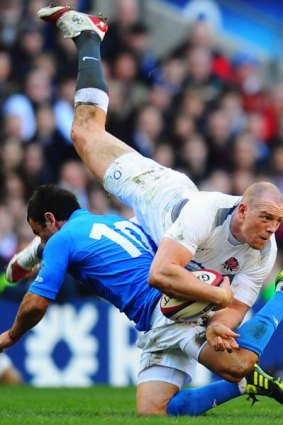 Mike Tindall of England looks to offload as he is tackled by Luciano Orquera of Italy.