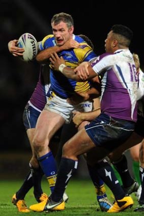 Jamie Peacock of Leeds is tackled by Siosaia Vave of the Storm during the World Club Challenge match.
