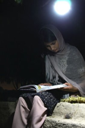 A Punjabi woman reads by the light of a Nokero bulb.