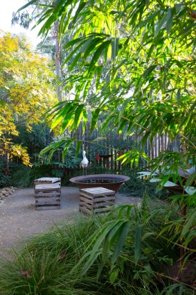 A fire pit and timber cubes create a cosy sitting area. 