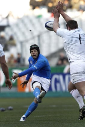 Vincent Debaty of France tries to charge down a kick by Australian-born Italy five-eighth Kris Burton.