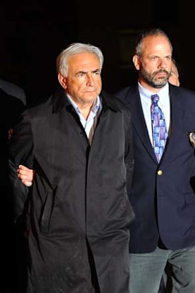 IMF head Dominique Strauss-Kahn (L) is taken out of a police station in New York. Strauss-Kahn was charged Sunday with attempting to rape a New York chambermaid.